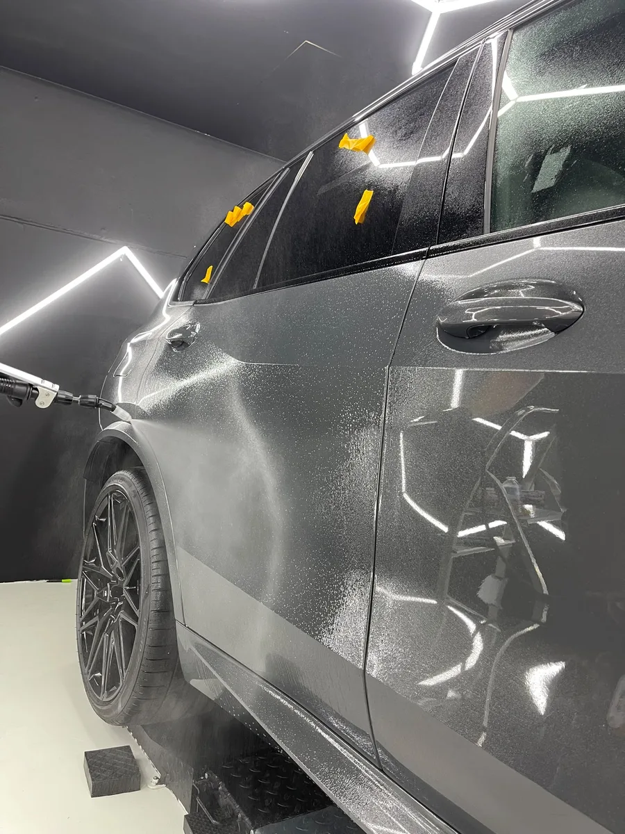 Application du traitement céramique sur une portière, carrosserie grise