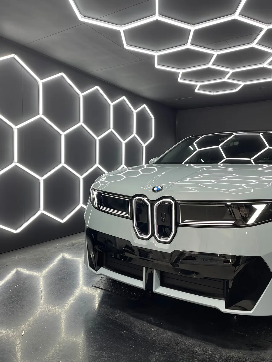 BMW XM blanche, calandre avant sous l’éclairage hexagonal