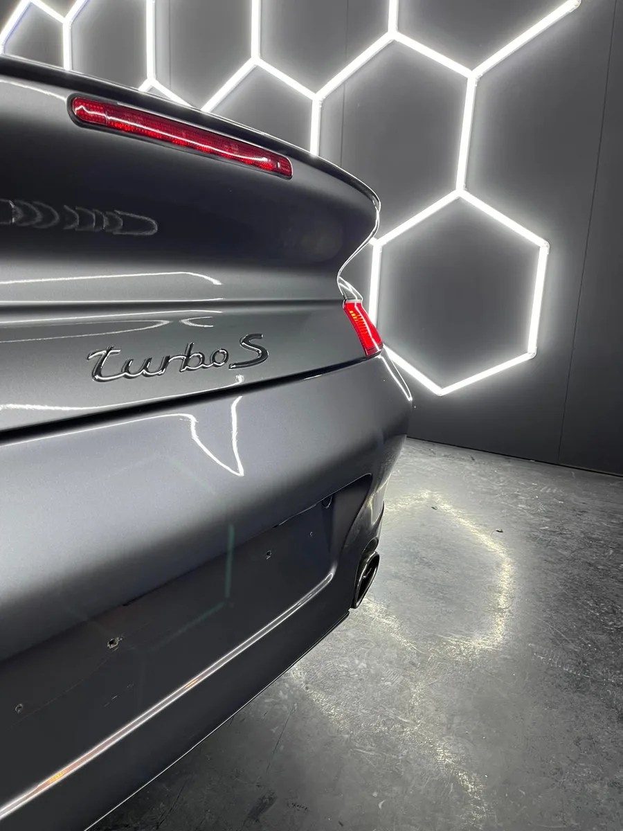 Détail de carrosserie sombre, reflet après traitement céramique
