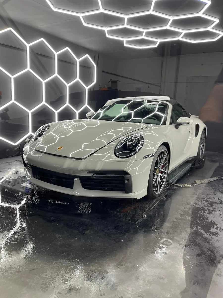 Porsche 911 blanche, vue 3/4 avant, carrosserie miroir