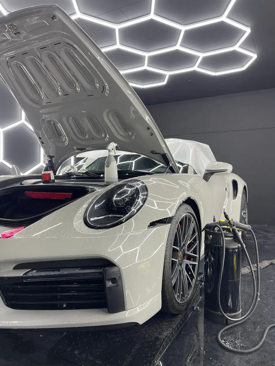Porsche 911 blanche, capot ouvert en préparation avant traitement