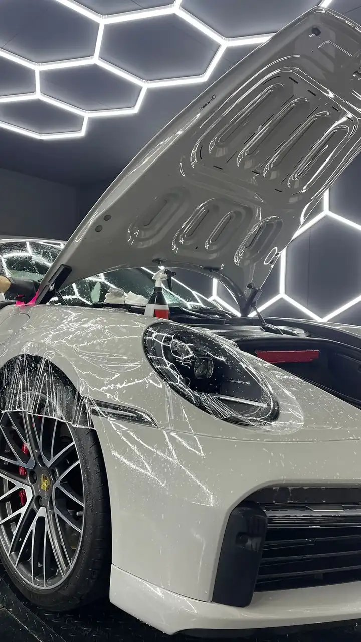 Porsche 911 recouverte de film de protection PPF en cours de pose dans l’atelier